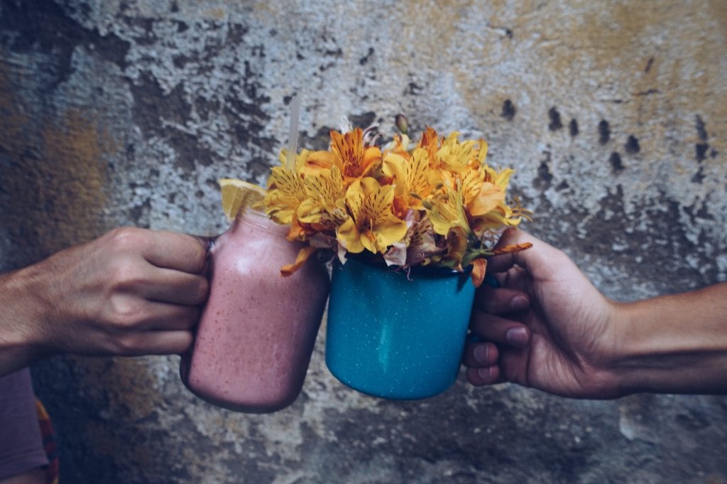 Two people greeting each other with flower mugs